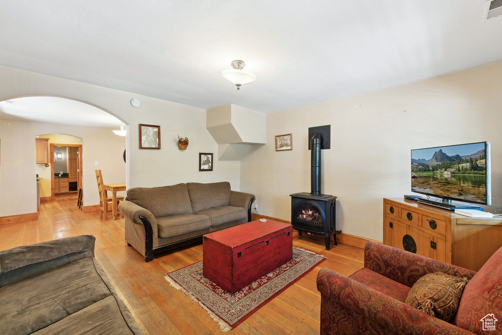 Living room featuring a wood stove and light hardwood / wood-style flooring