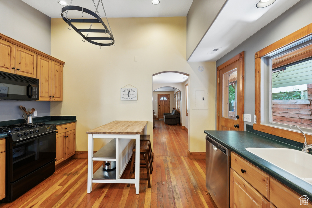 Kitchen featuring wooden counters, sink, light hardwood / wood-style flooring, and black appliances