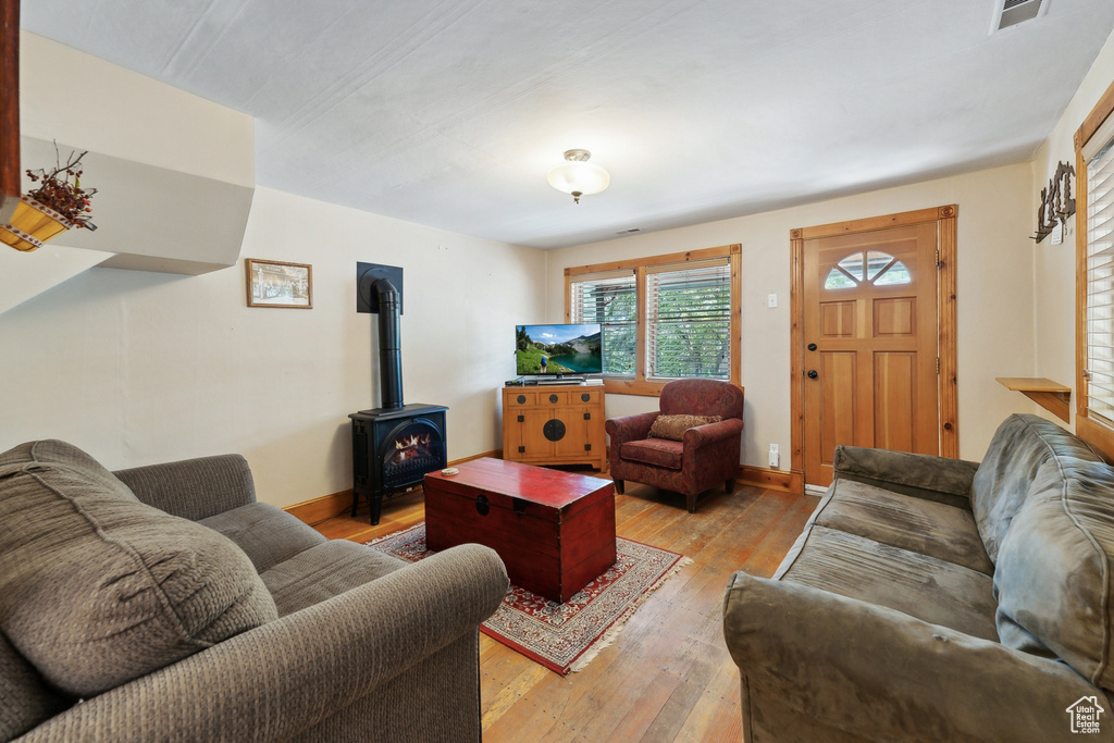 Living room with light hardwood / wood-style floors and a wood stove