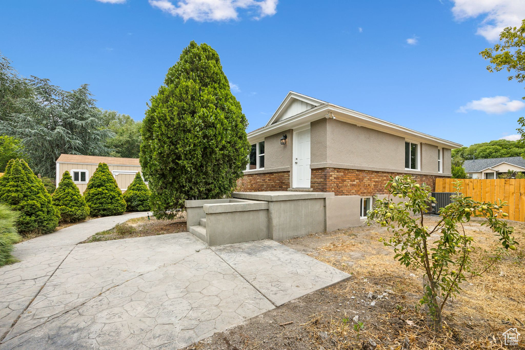 View of side of home with a patio and central AC