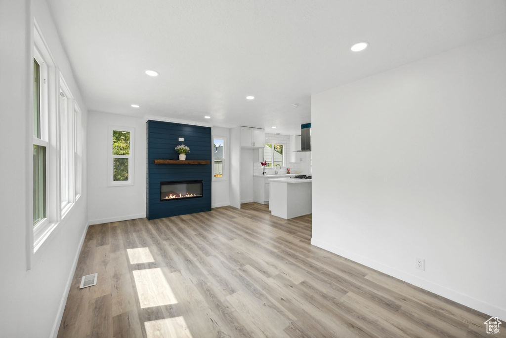 Unfurnished living room with a fireplace and light hardwood / wood-style flooring