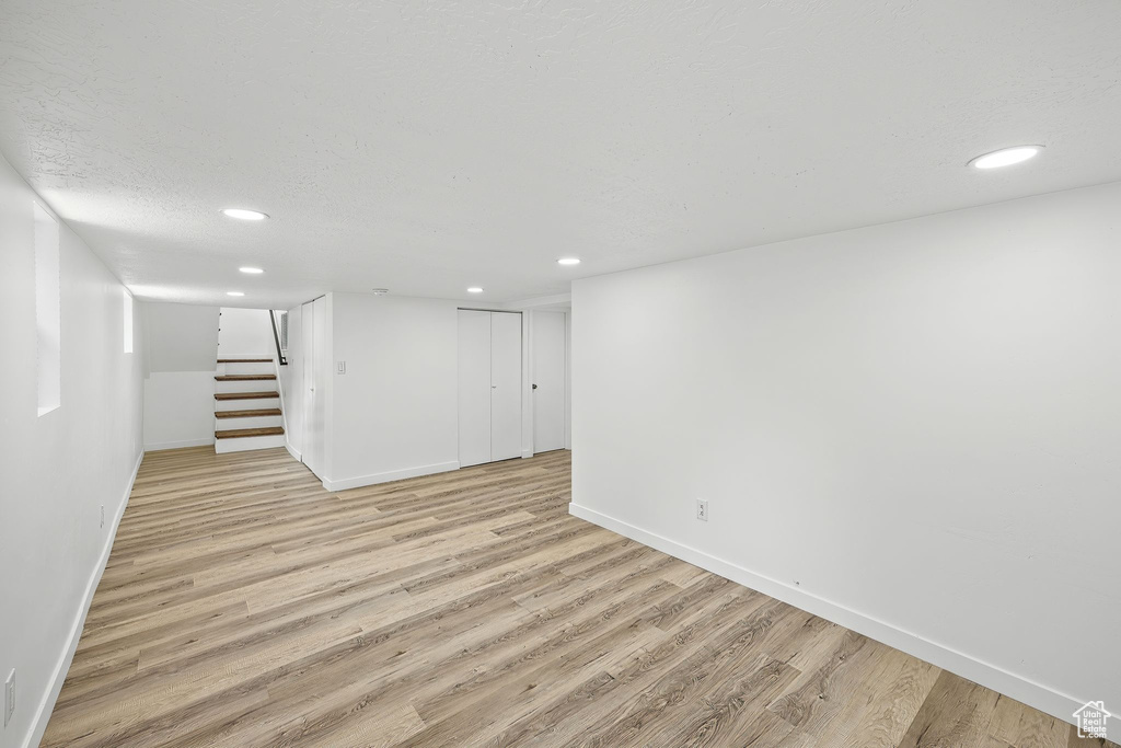 Basement with light wood-type flooring