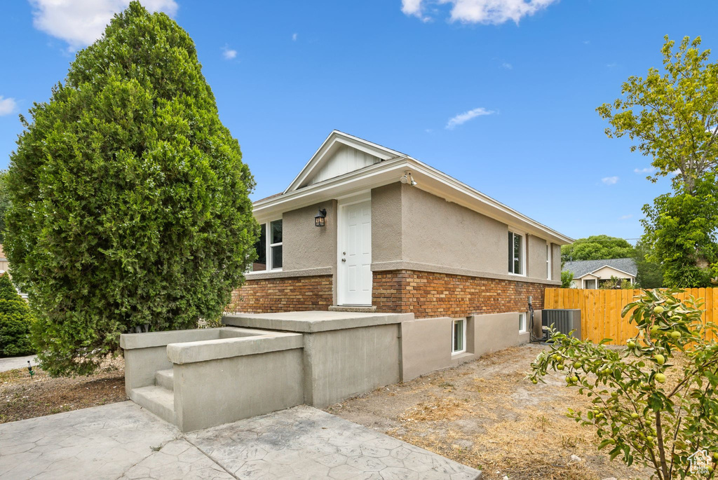 View of side of home with central AC and a patio