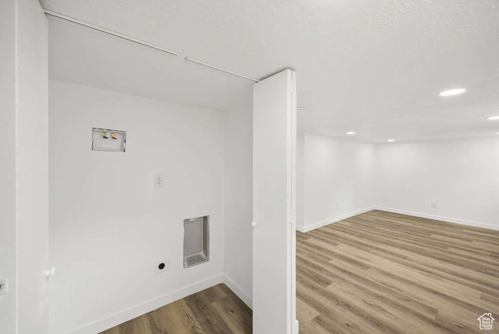 Laundry area with hardwood / wood-style flooring, hookup for an electric dryer, and washer hookup