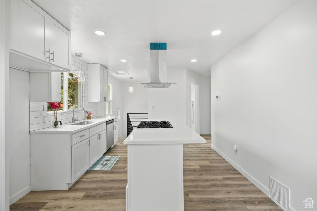 Kitchen featuring white cabinetry, light hardwood / wood-style flooring, and island exhaust hood