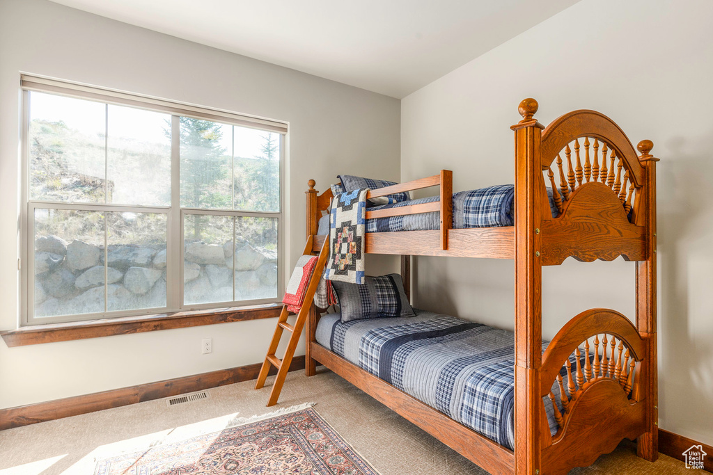 Carpeted bedroom featuring visible vents and baseboards