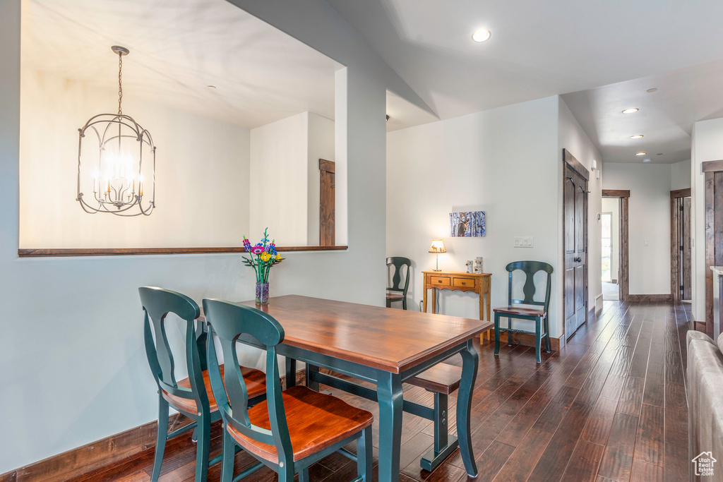 Dining room with dark wood-type flooring, a chandelier, baseboards, and recessed lighting