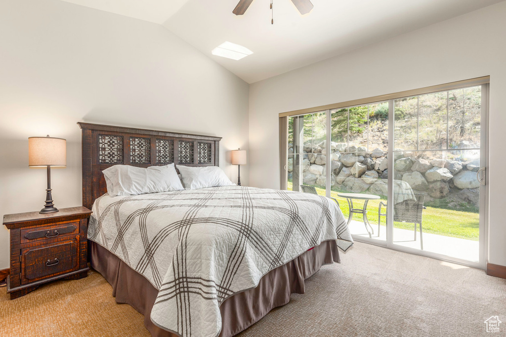 Bedroom with vaulted ceiling, carpet, access to exterior, and a ceiling fan