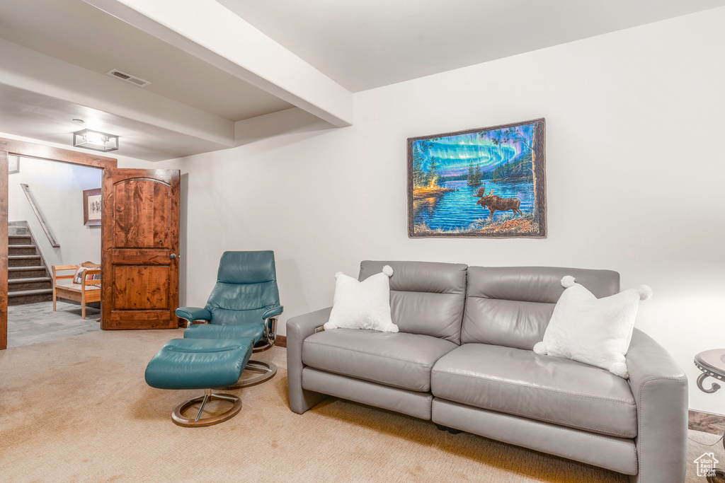 Carpeted living area featuring visible vents and stairs