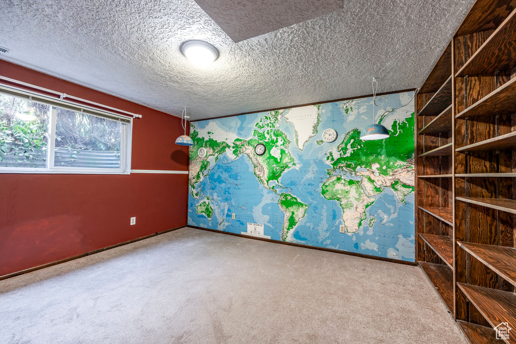 Carpeted spare room featuring a textured ceiling