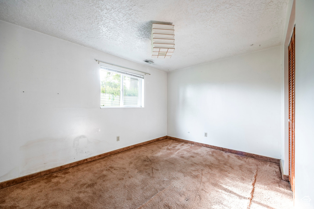 Unfurnished bedroom featuring carpet flooring and a textured ceiling