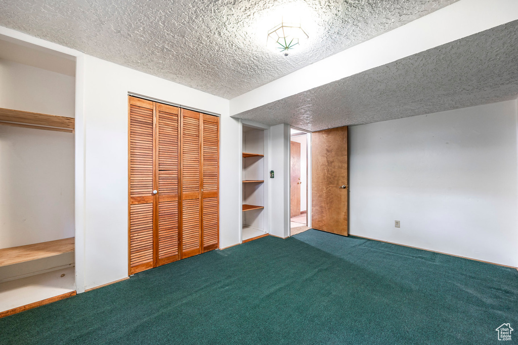 Unfurnished bedroom with multiple closets, a textured ceiling, and carpet flooring