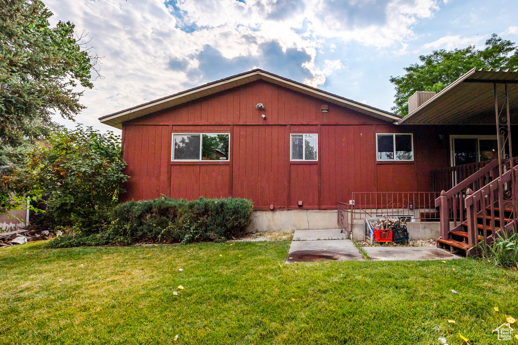 Rear view of property featuring a patio area and a lawn