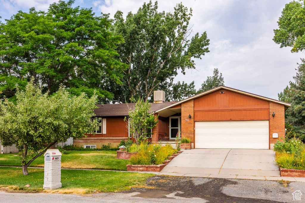 Single story home with a garage and a front yard