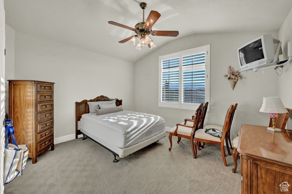 Carpeted bedroom featuring ceiling fan and lofted ceiling