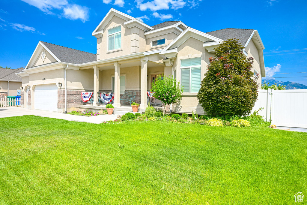 Craftsman-style house with covered porch, a garage, and a front yard