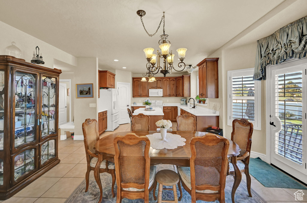 Dining room featuring light tile patterned flooring, a notable chandelier, and sink