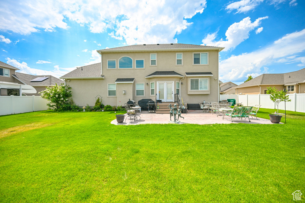 Back of house featuring a lawn and a patio area