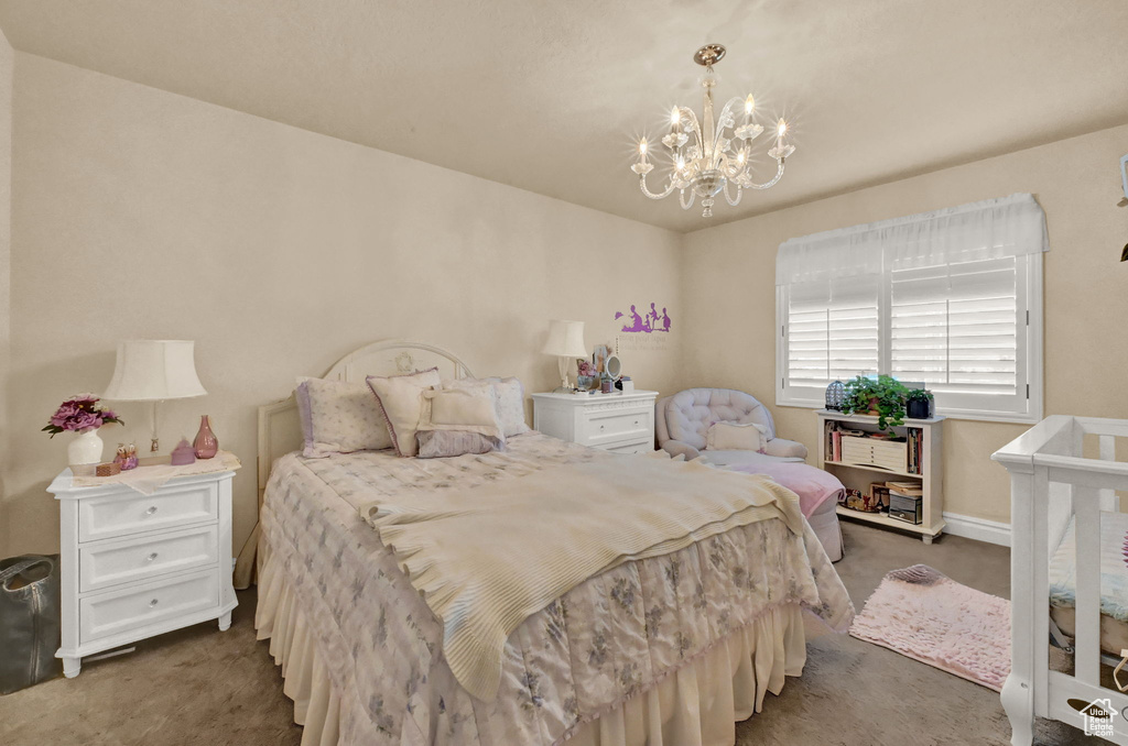 Carpeted bedroom featuring a notable chandelier