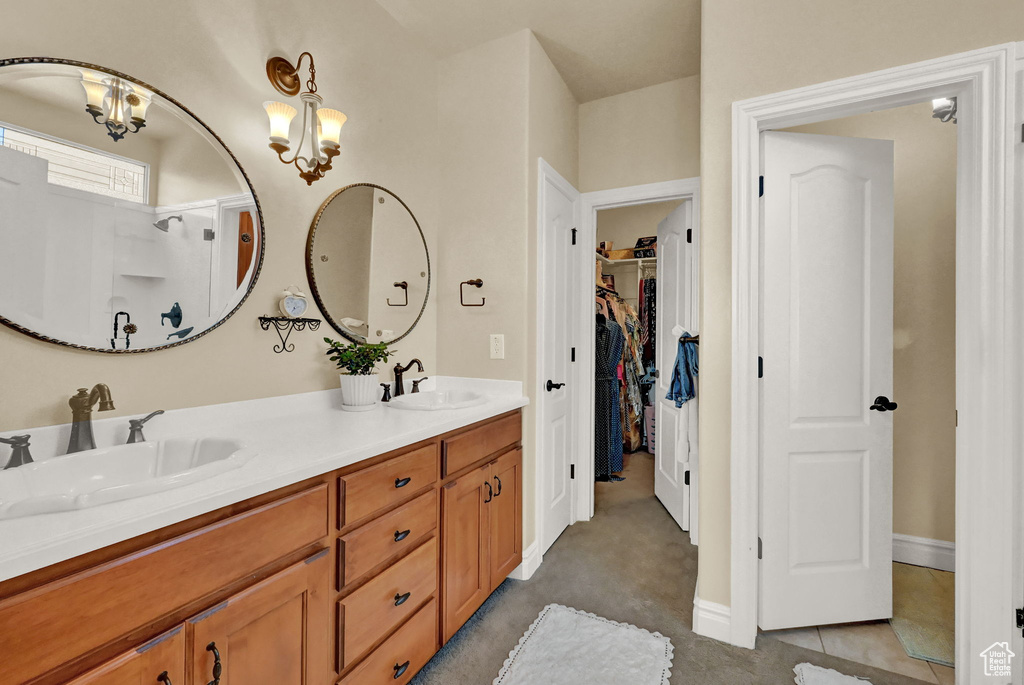 Bathroom featuring an inviting chandelier and double vanity