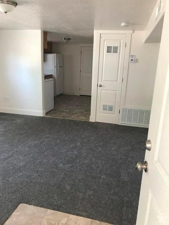 Unfurnished living room with carpet and a textured ceiling