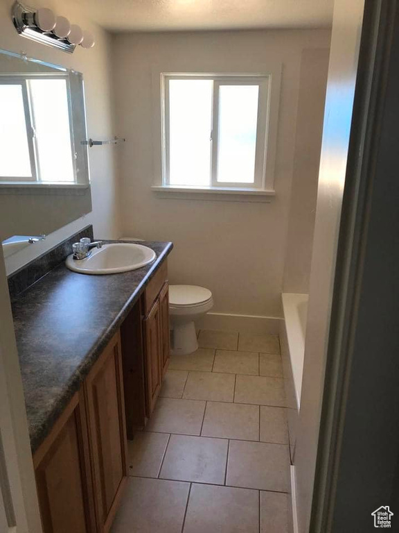 Bathroom with tile patterned floors, toilet, and vanity