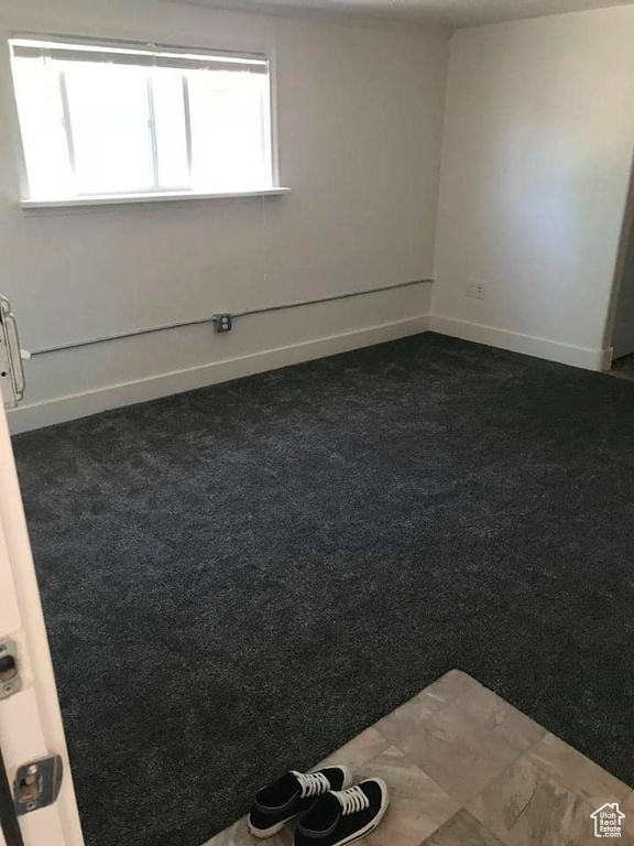 Spare room featuring dark carpet