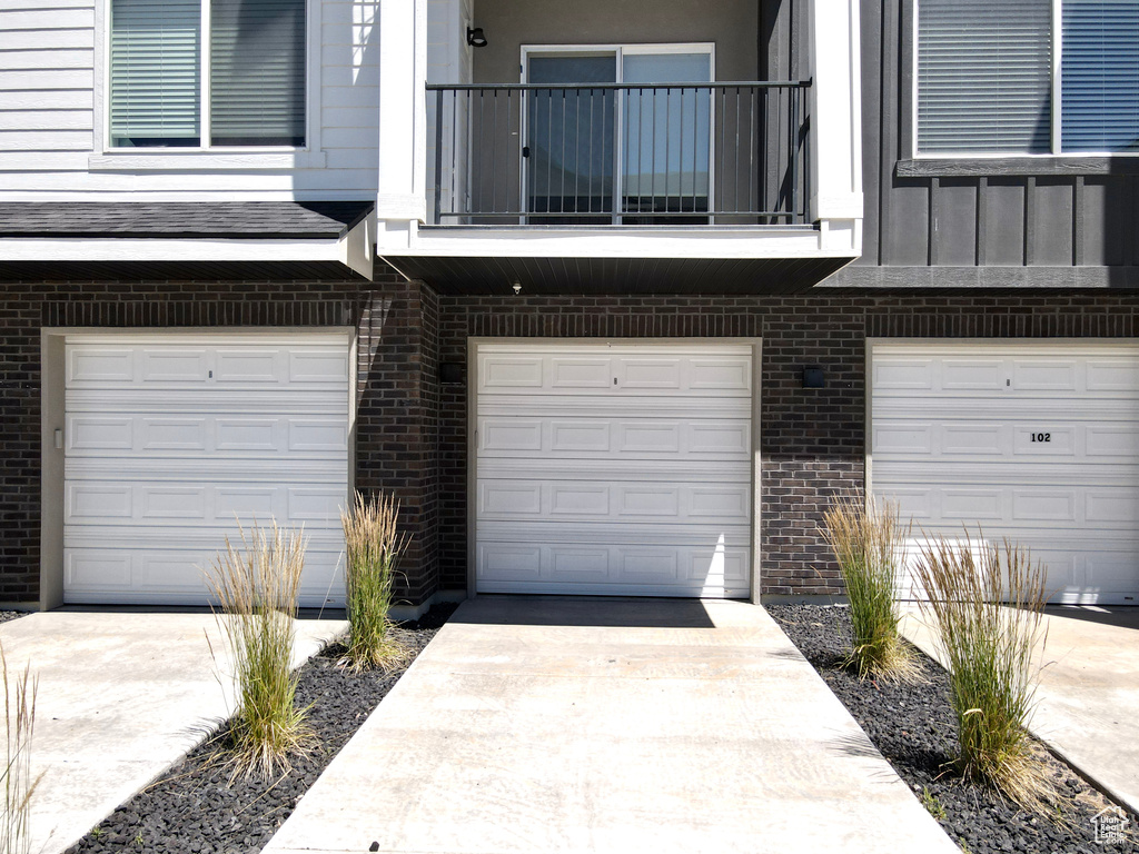 Entrance to property featuring a balcony and a garage