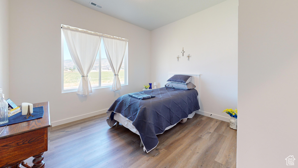 Bedroom with hardwood / wood-style flooring