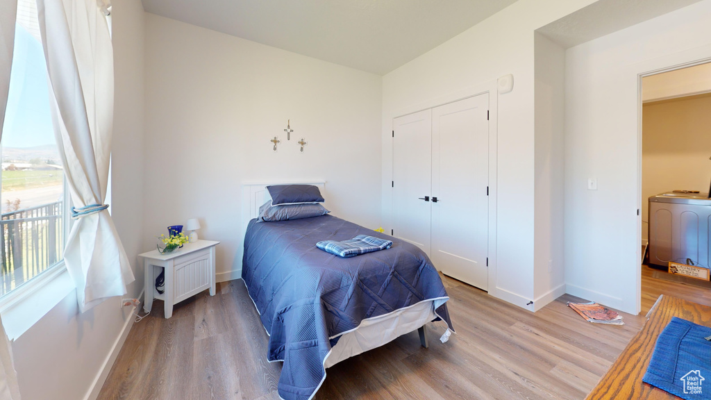 Bedroom featuring washer / clothes dryer, a closet, and light wood-type flooring