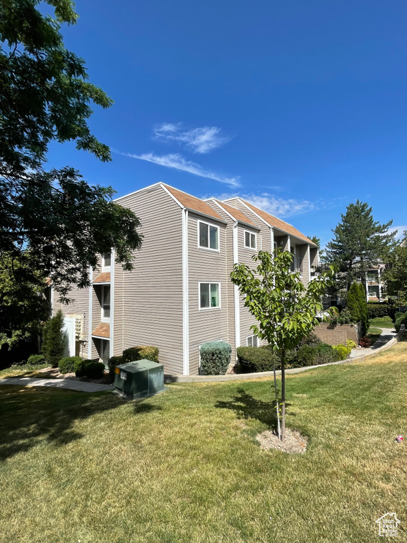 View of side of home featuring a lawn