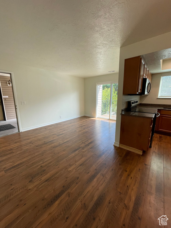 Kitchen featuring range, a textured ceiling, and dark hardwood / wood-style flooring