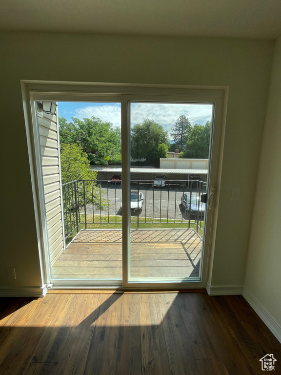 Doorway to outside featuring wood-type flooring and a healthy amount of sunlight