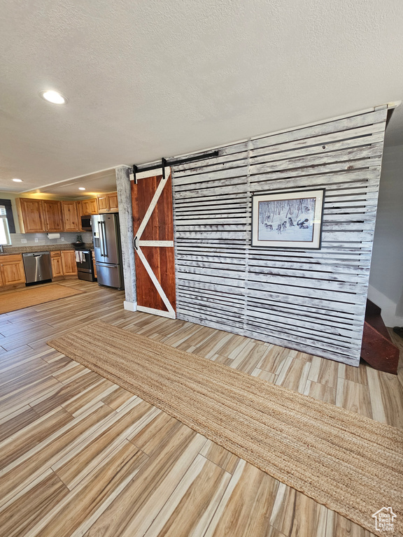 Interior space with a textured ceiling and a barn door