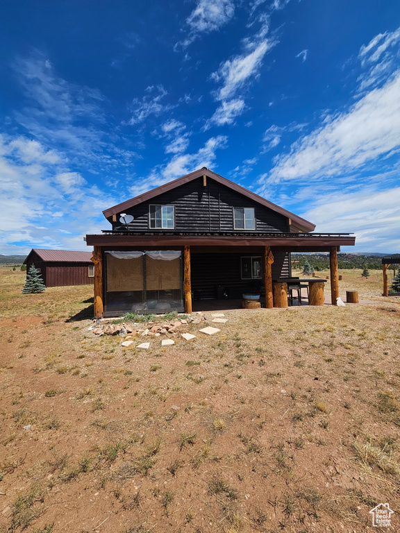 View of front of house with an outdoor structure and a front lawn