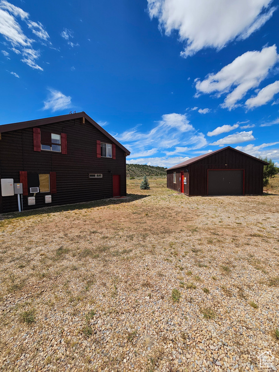 View of yard with a garage and an outdoor structure