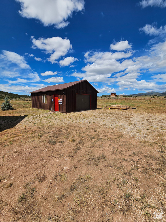 View of outdoor structure with a garage and a rural view