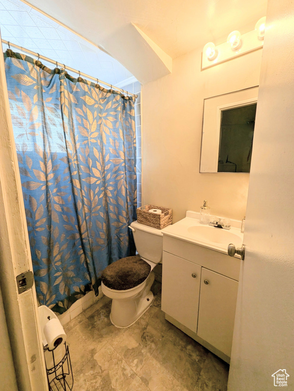 Bathroom with tile patterned floors, a shower with shower curtain, toilet, and vanity