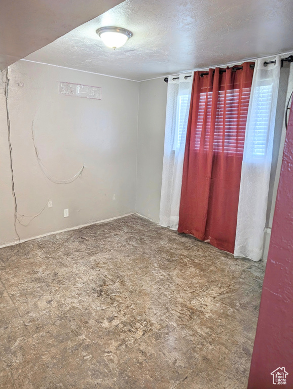 Unfurnished room featuring a textured ceiling and tile patterned floors