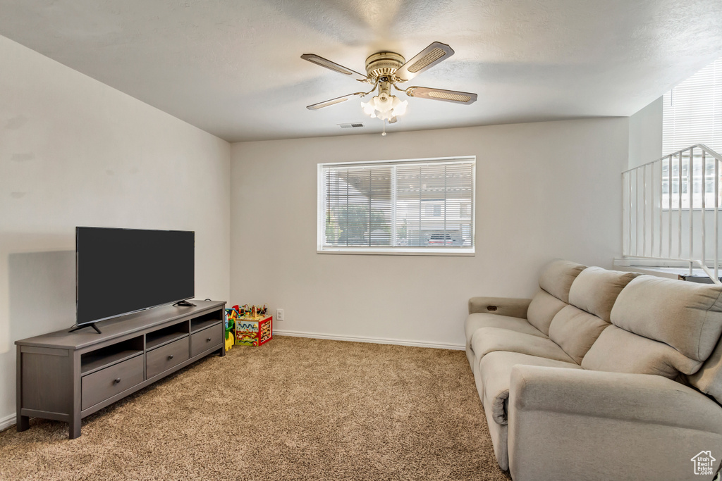 Living room with light carpet and ceiling fan