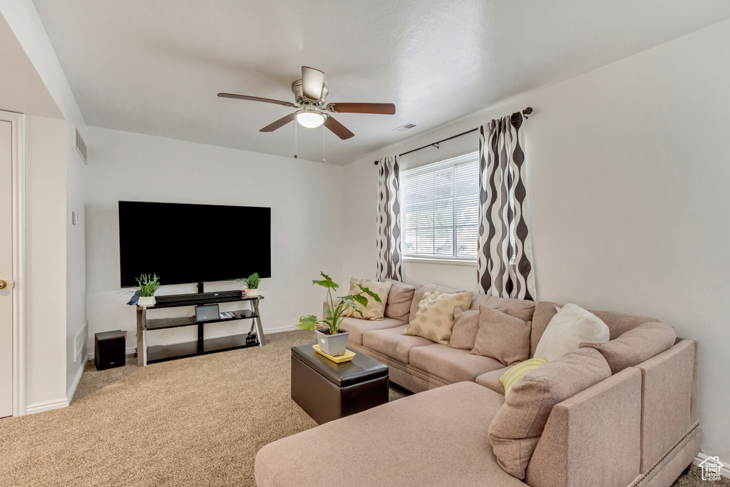 Carpeted living room with ceiling fan