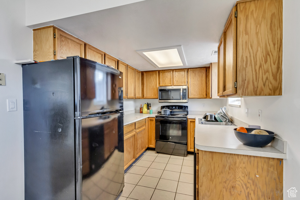 Kitchen featuring black appliances and light tile patterned floors