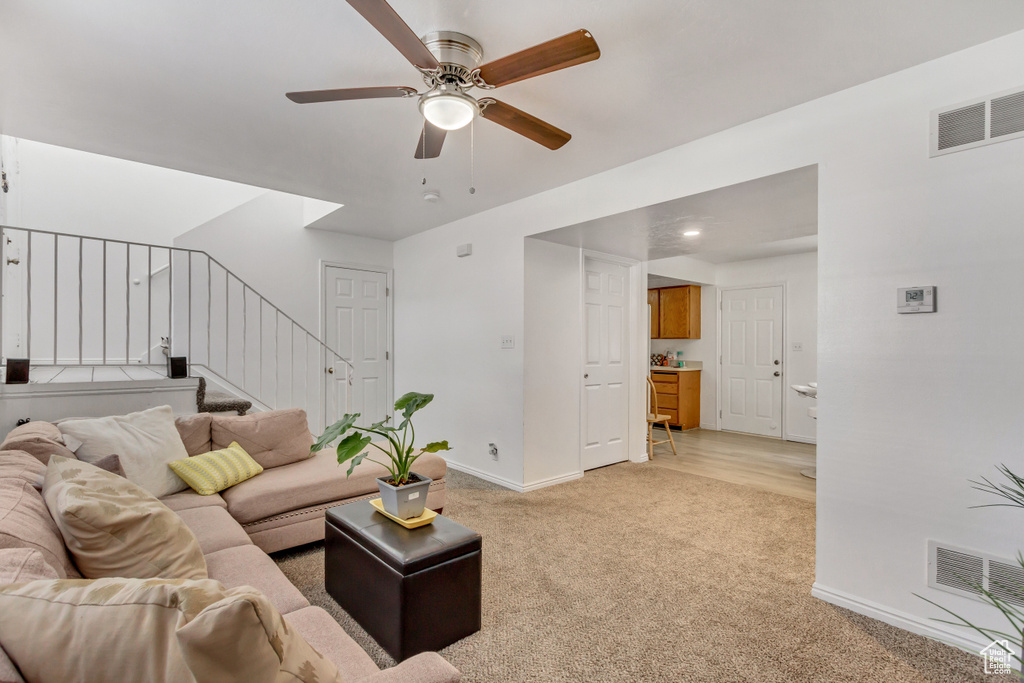 Carpeted living room with ceiling fan