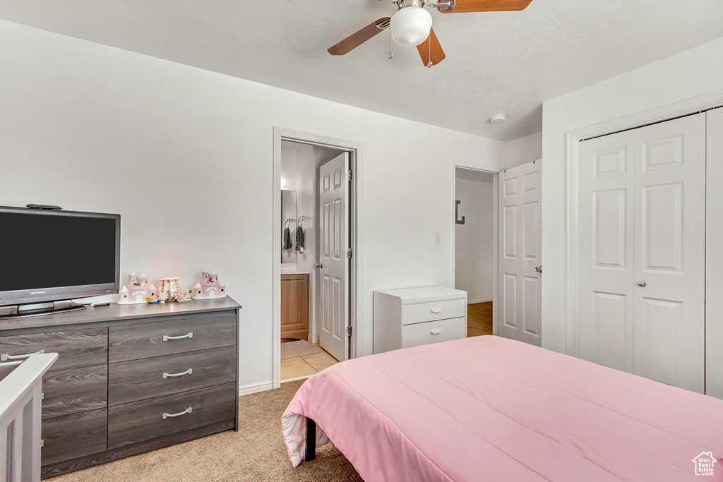 Carpeted bedroom featuring connected bathroom, a closet, and ceiling fan