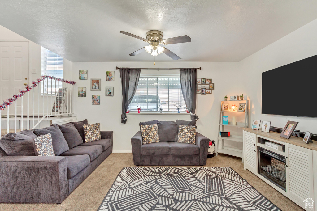 Living room with light colored carpet and ceiling fan