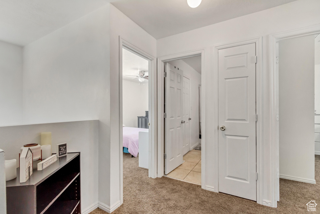 Hallway featuring light colored carpet