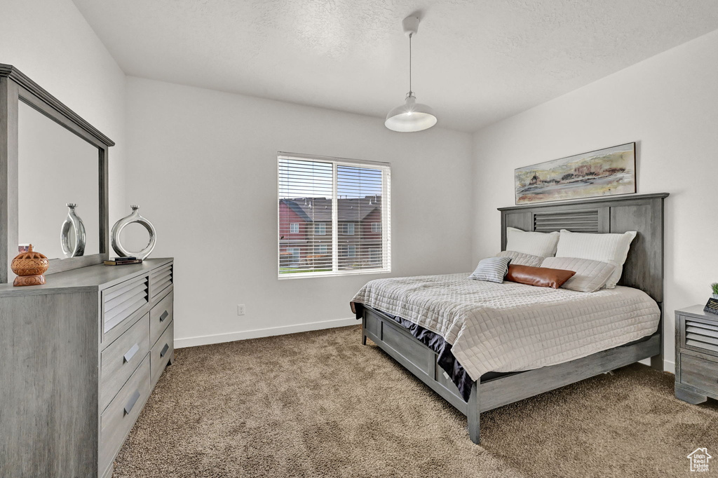 Bedroom with a textured ceiling and light colored carpet