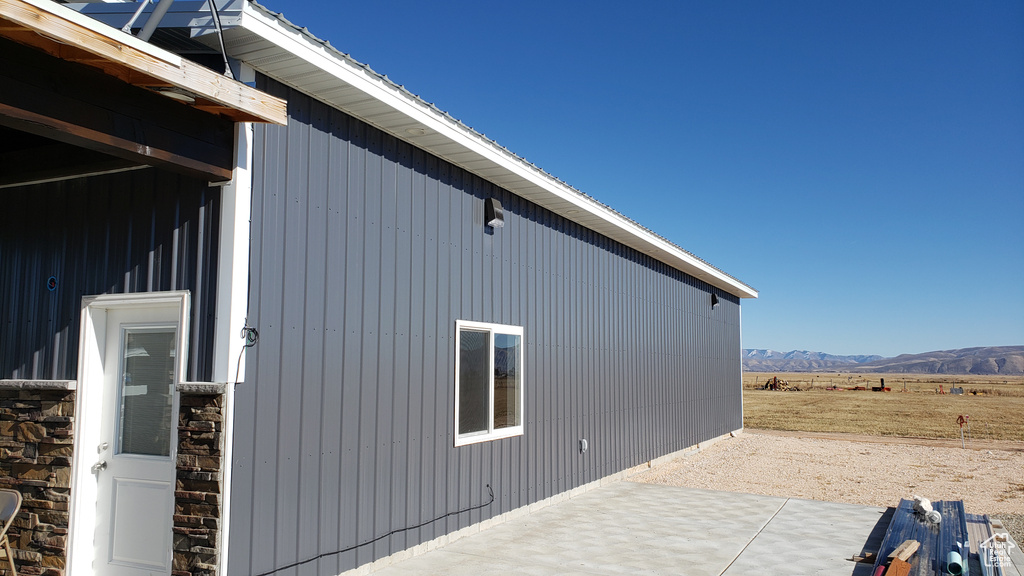 View of side of home featuring a mountain view and a patio area