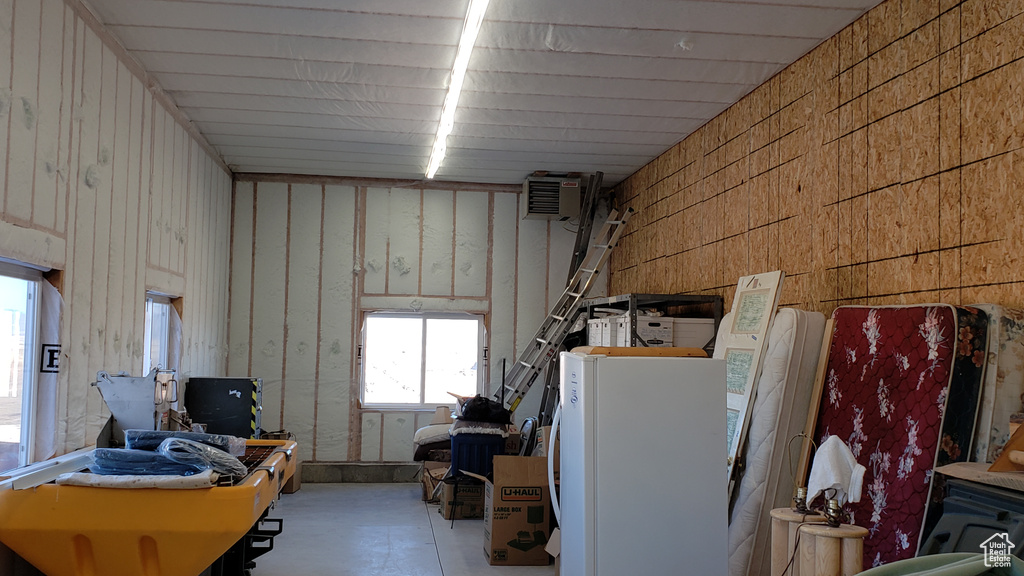 Interior space with white refrigerator and a wall mounted air conditioner