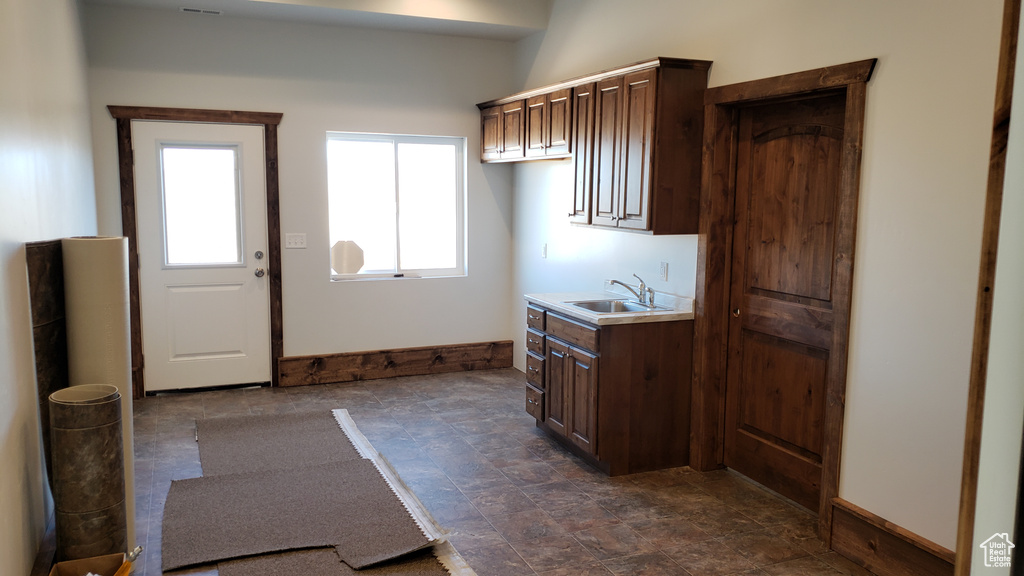 Interior space featuring sink and dark tile patterned floors